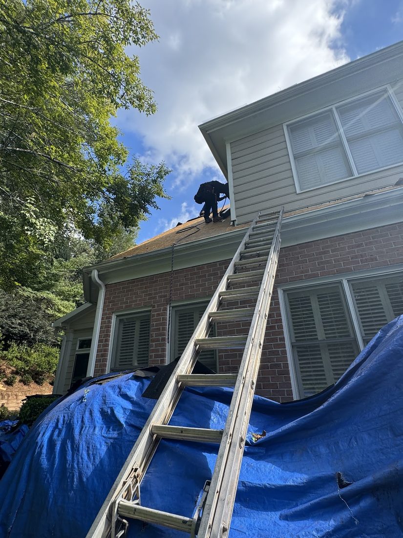 Storm-damaged roof protected with a tarp during repairs