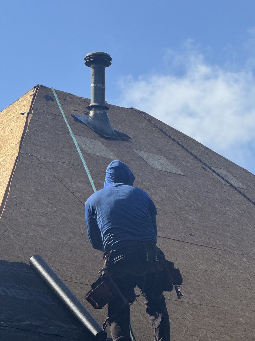 LB Roofing technician working on a residential roof and chimney